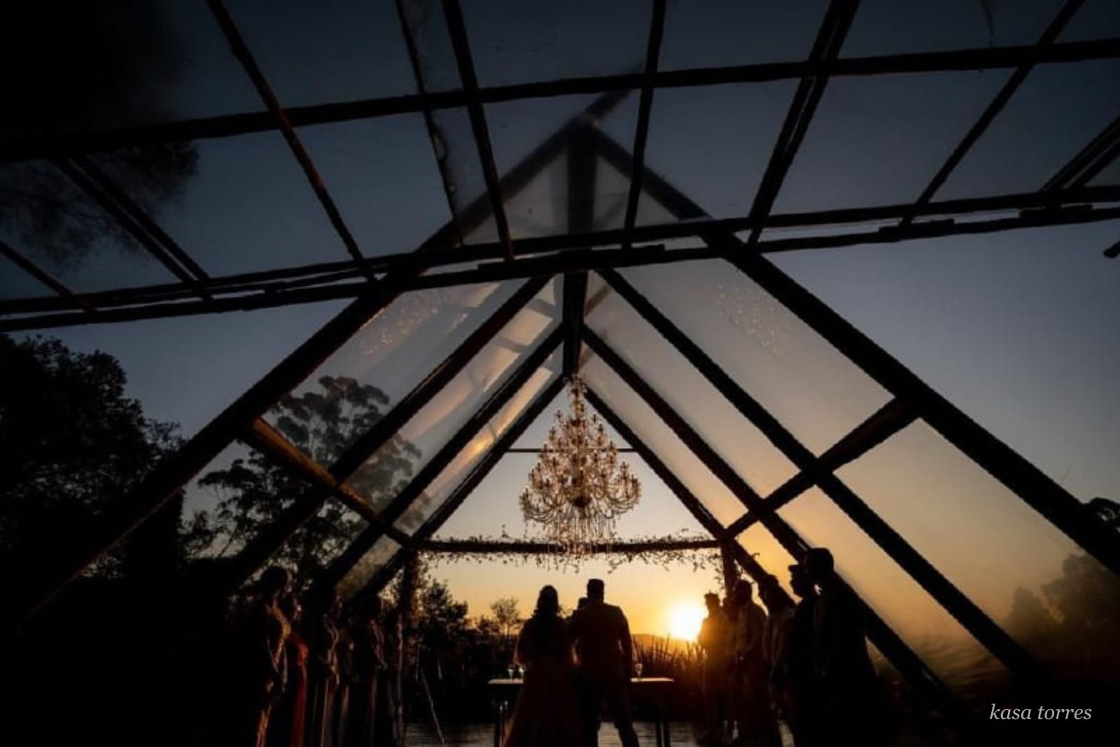 Cerimônia íntima em estufa de vidro ao pôr do sol com lustre de cristal — Kasa Torres